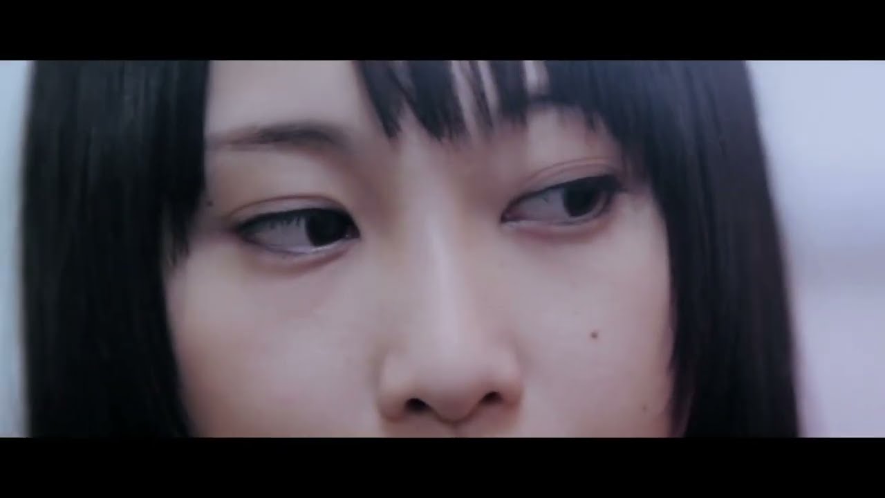 ske48 kataomoi finally music video screenshot: extreme close up of matsui rena, only her eyes and the top of her head visible, as she looks to the side, her head partially tilted.
